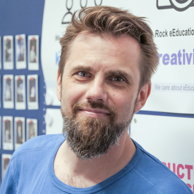 Foto von Walther Nagler: Er hat einen Vollbart und steht vor einem Rollup zum Thema eEducation